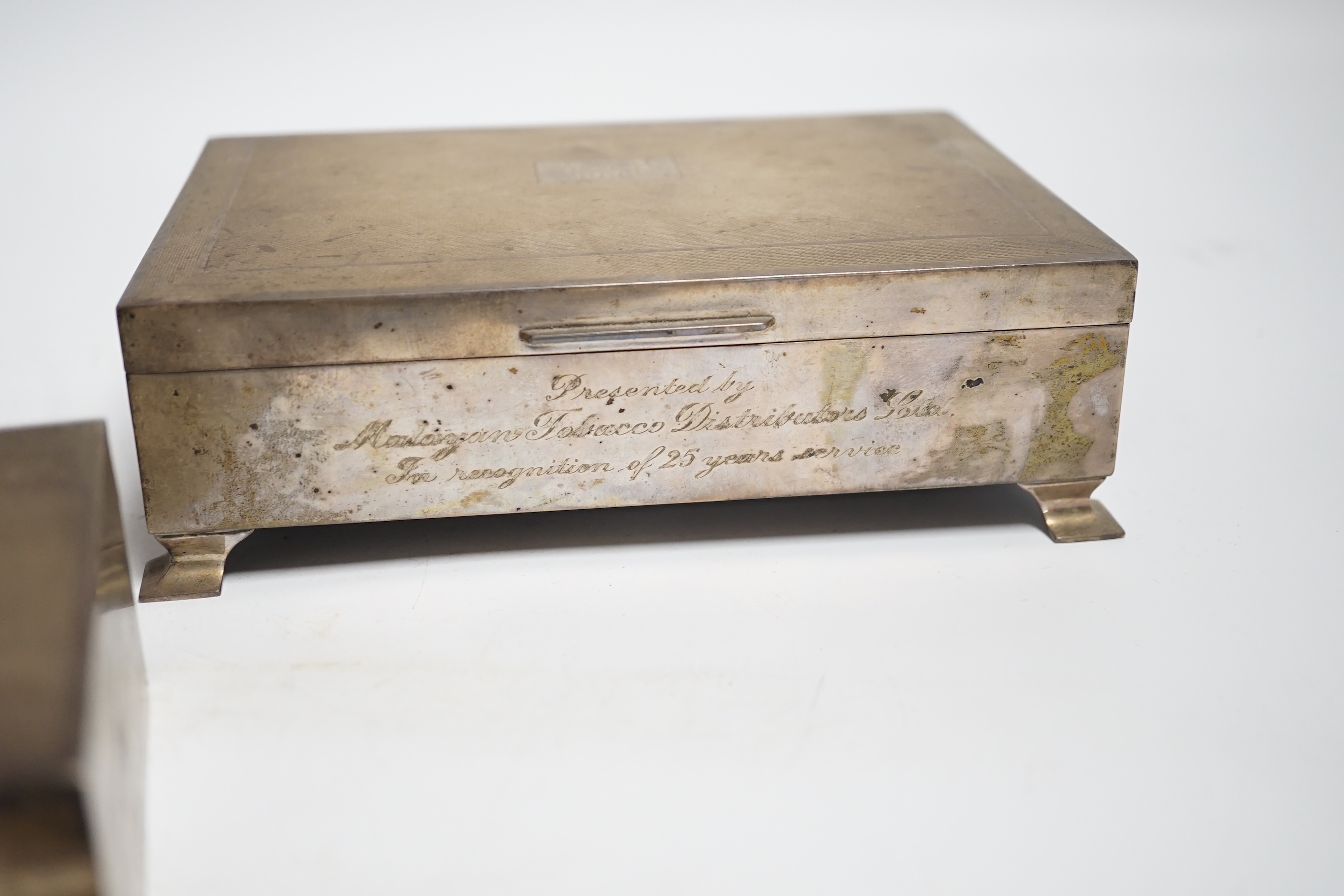 Two engine turned silver mounted cigarette boxes, the largest by Garrard & Co, London, 1955, 16.9cm and a silver trinket box.